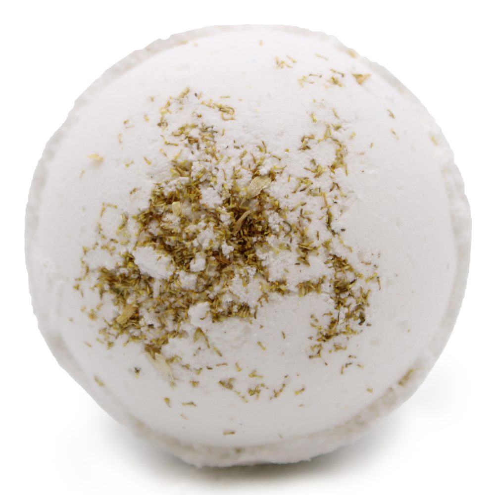 A round, white bath bomb with green herb-like particles on its surface, set against a plain white background.