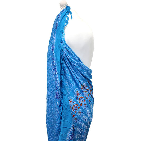 A blue sarong, draped on a mannequin, displays a patterned design.