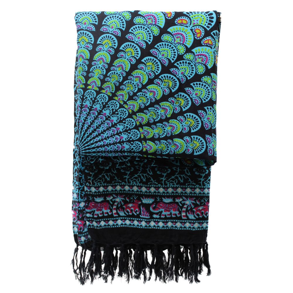 A patterned sarong, folded, displays mandala and elephant designs in teal, pink, and green on black. It features a fringed bottom edge.