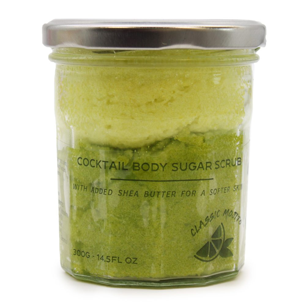 A lidded jar is filled with a two-tone green body scrub. The label reads, "COCKTAIL BODY SUGAR SCRUB WITH ADDED SHEA BUTTER FOR A SOFTER SKI CLASSIC Mojito 300G-14.5FL OZ". The jar sits on a white surface.