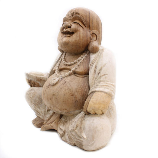 A wooden statue of a laughing figure holding a bowl, adorned with a necklace, sitting cross-legged. The background is plain white.