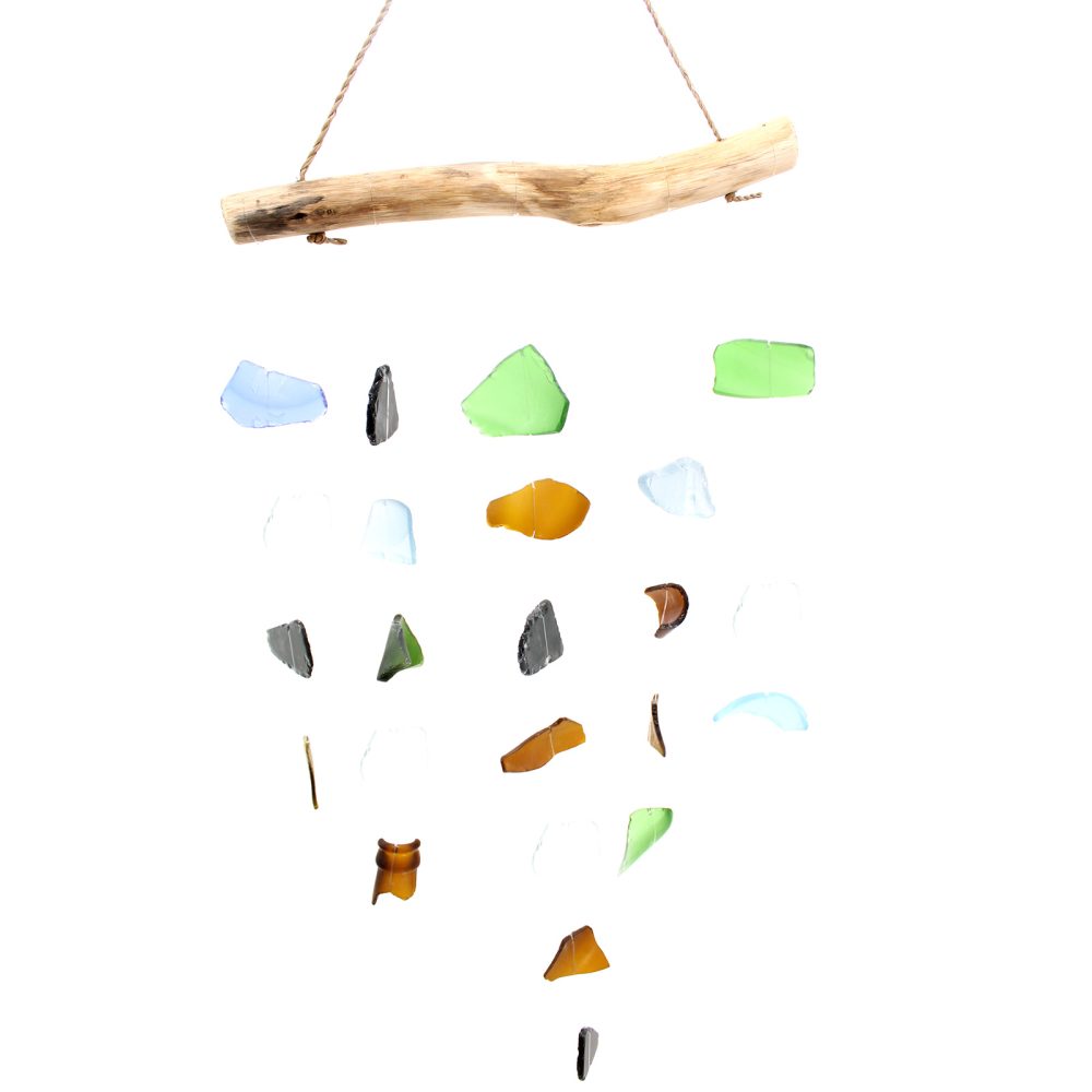 A driftwood-hung mobile, dangling multicolored glass shards, hangs against a white backdrop.