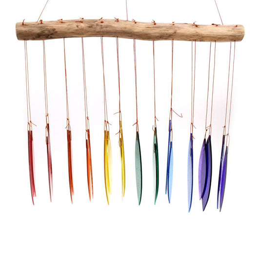 A wood branch hangs from a string, suspending numerous glass oval pieces of varying rainbow colors which gently chime.