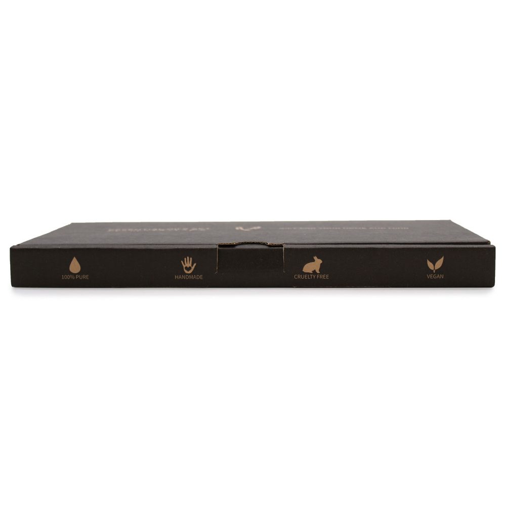 A brown, rectangular box is sitting flat on a white surface, showing icons and text: "100% PURE," a hand icon with "HANDMADE", a rabbit icon with "CRUELTY FREE" and a leaf icon with "VEGAN."