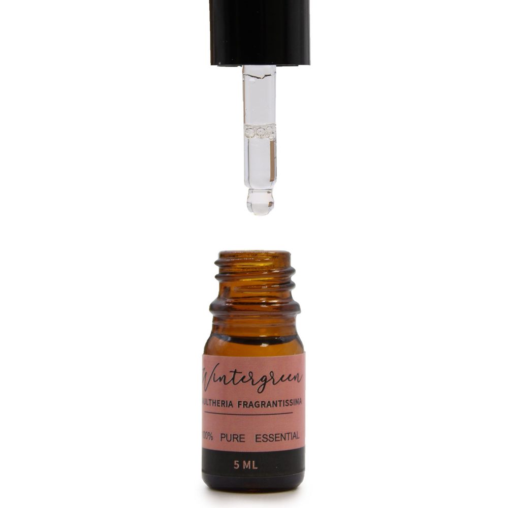 A bottle of "Wintergreen" essential oil is shown open with a dropper hovering above on a white background. The label says: "Wintergreen, ULTHERIA FRAGRANTISSIMA, 100% PURE ESSENTIAL, 5 ML".