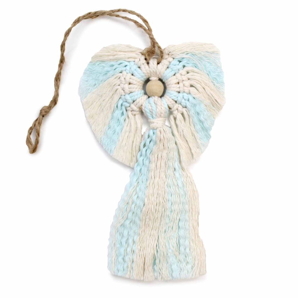 Macrame angel ornament dangles by a jute string against a white background. Alternating bands of cream and blue yarn form the angel's wings and dress. A wooden bead marks its head.