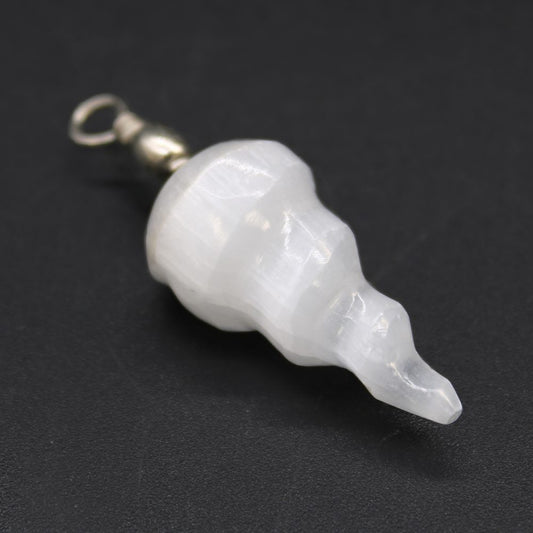 A white, cylindrical selenite pendant, with carved curves in its form, hangs attached to a silver bail, on a black background.