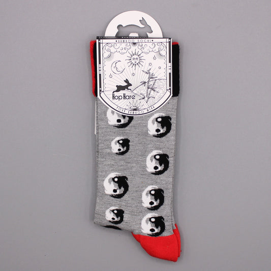 A pair of grey socks, featuring a yin-yang pattern, hangs from a card. The card displays the brand "Hop Hare" and reads "*Bamboo Socks* Your Bamboo Wear." The socks have red cuffs.