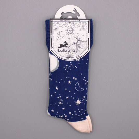 A pair of navy blue socks, featuring a celestial design, is displayed on a gray background; the socks are attached to a card that reads "*BAMBOO SOCKS*", "Hop Hare", and "YOUR BAMBOO WEAR".