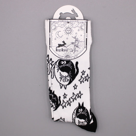 White socks with a black yin-yang cat and star pattern hang from a tag. The tag reads "*BAMBOO SOCKS*", a rabbit illustration, "Hop Hare", and "YOUR BAMBOO WEAR".