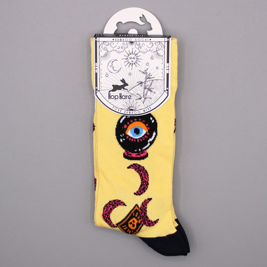 Yellow bamboo socks, featuring crescent moons and a crystal ball design, hang on a display card against a gray background. The card reads: “Bamboo Socks *BAMBOO SOCKS* Hop Hare YOUR BAMBOO WEAR”.