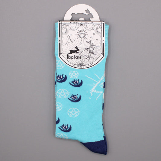 A pair of light-blue socks, displaying crescent moons and pentagrams, hangs from its packaging against a grey background. The packaging reads: *BAMBOO SOCKS*, *Hop Hare*, *YOUR BAMBOO WEAR*.