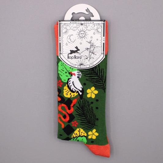 A pair of socks displays a tropical print, hangs from a tag, against a gray background. The tag reads: *BAMBOO SOCKS* Hop Hare YOUR BAMBOO WEAR.