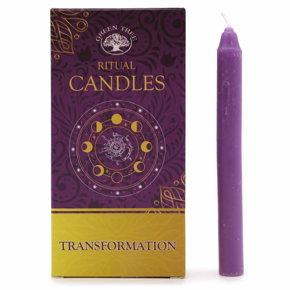 A purple candle stands beside a box on a white surface. The box reads "GREEN TREE," "RITUAL CANDLES," and "TRANSFORMATION" against purple and gold backgrounds.