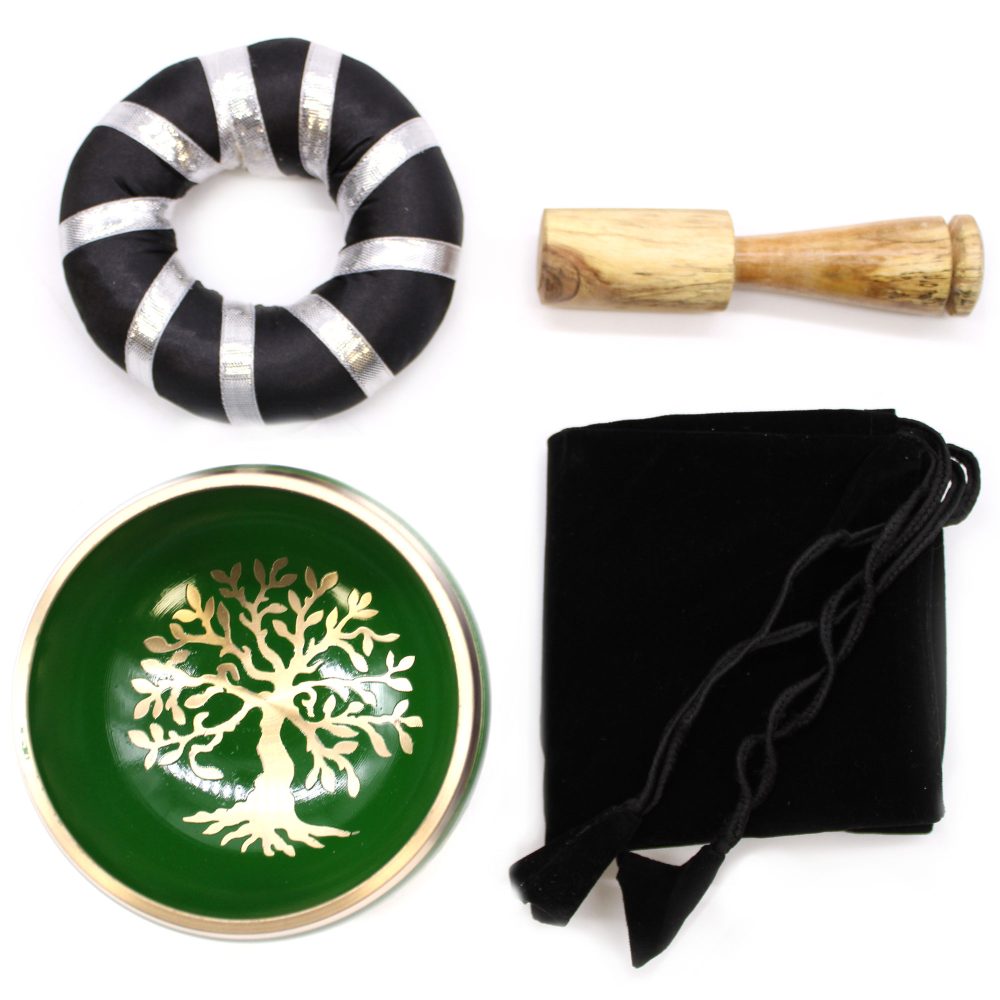 A green singing bowl with a golden tree design, a wooden mallet, a black striped cushion, and a black cloth bag are arranged on a white background.