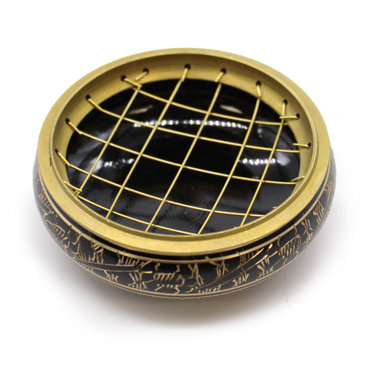 A decorative black and gold bowl with intricate engravings on the exterior, features a golden wire grid cover, placed against a plain white background.
