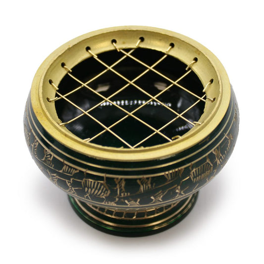 A round incense burner with a metal grid on top, featuring intricate gold patterns on a dark base, sitting on a flat surface in bright lighting.