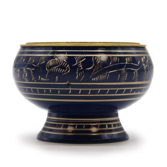 A round, dark blue ceramic bowl with intricate golden etchings of figures and lines sits on a matching pedestal base against a plain white background.