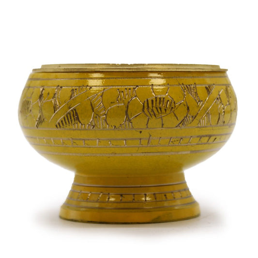 A round, yellow ceramic bowl features intricate engraved floral patterns. It rests on a short pedestal, creating a raised base, and sits against a plain white background.