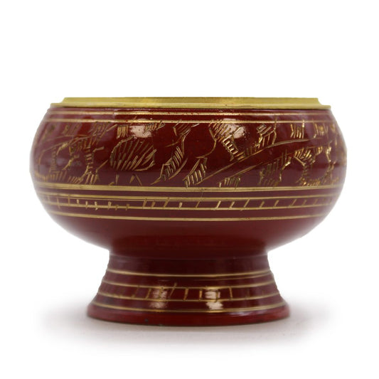 A red, decorative lacquer bowl rests on a pedestal, featuring gold engraved patterns of leaves. The bowl is shown against a plain white background.