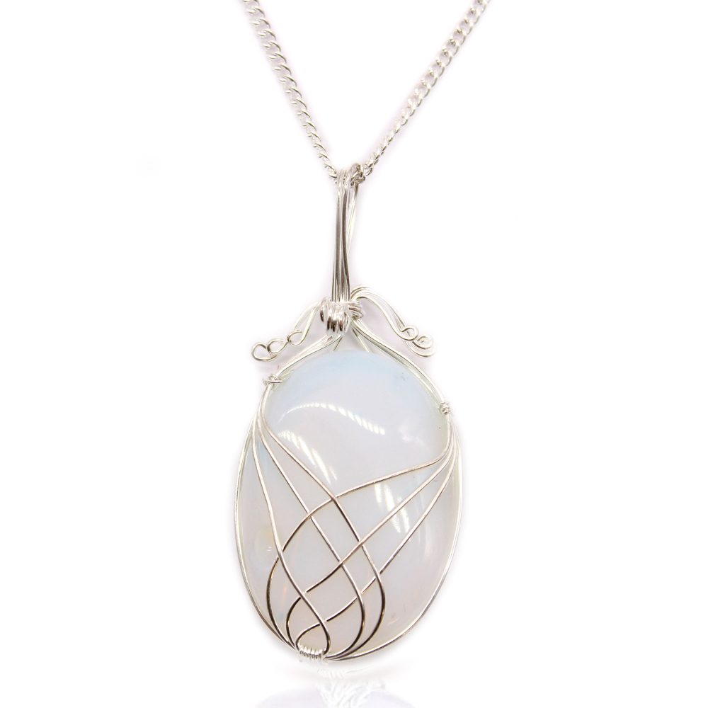 An oval, pearly white gemstone is caged within a silver wire pendant attached to a silver chain, all laying against a white background with a slight reflection.