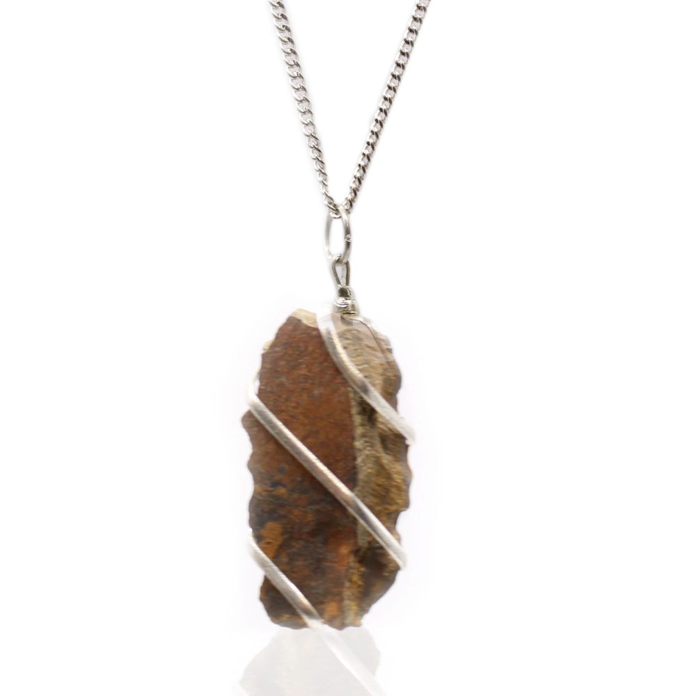 A brown stone pendant wrapped with silver wire dangles from a silver chain against a bright white background.