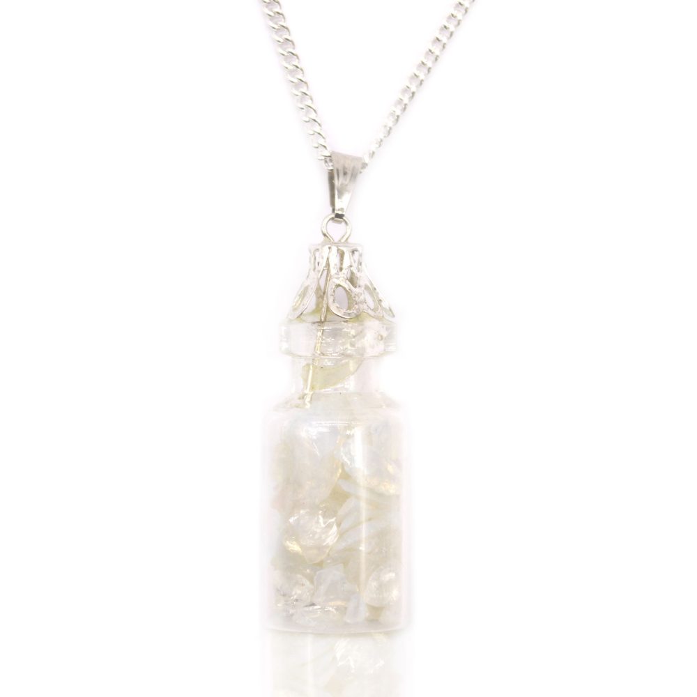 A small, clear glass bottle pendant filled with white shards hangs from a silver chain. The bottle has a decorative silver cap and sits against a white background.