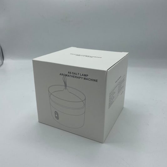 A white box sits on a gray surface. The box features an illustration of an A6 Salt Lamp Aromatherapy Machine, with the same text printed above the drawing.