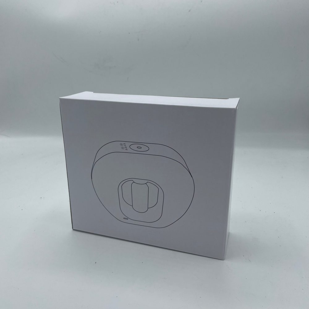 A white product box sits on a white surface, with a line drawing of a round device printed on the box's face.