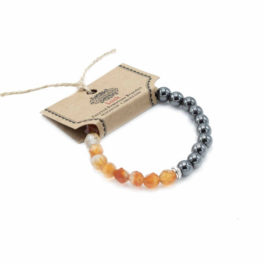 A beaded bracelet lies angled on white. The bracelet is half orange/white stones, half silver metallic stones, joined by a silver bead. Attached is a tan tag reading “ACCESSORIES, Luck, Faceted Gemstone Bracelet, MAGNETIC CARNELIAN.”