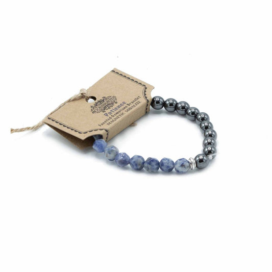 A bracelet with faceted blue and gray beads and magnetic sodalite is displayed with a tag labeled “Patience” against a white background.