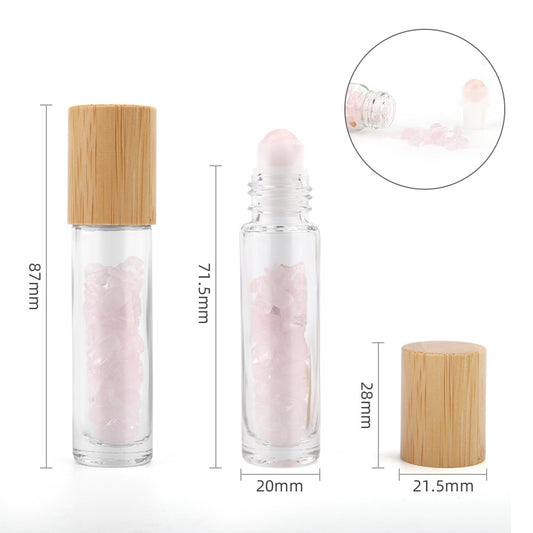Two clear bottles containing pink crystals are displayed, one with a wooden cap and one with a rollerball. Dimensions are indicated: 87mm, 71.5mm, 20mm, 28mm, and 21.5mm. A circle shows an open bottle spilling out pink crystals.