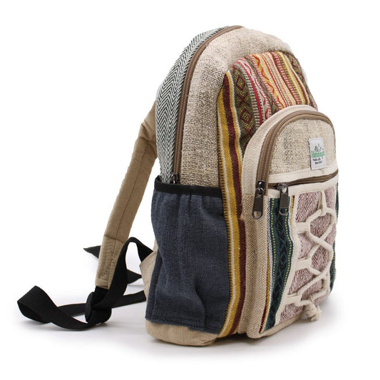 A backpack with various vertical stripes and patterns sits on a white surface. A small tag on the front pocket reads: "Himalayan made with Hemp."