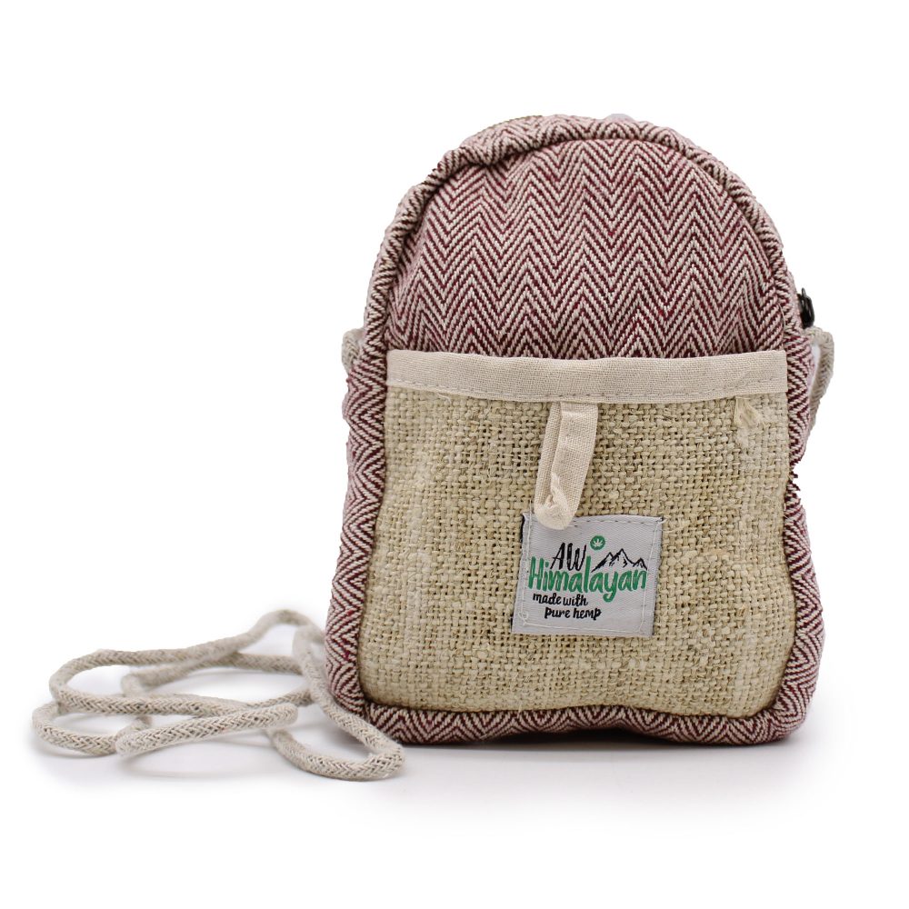 A small hemp bag with a brown and white zig-zag pattern stands on a white surface. A tag on the front reads "AW Himalayan made with pure hemp". A long strap lies to the side.
