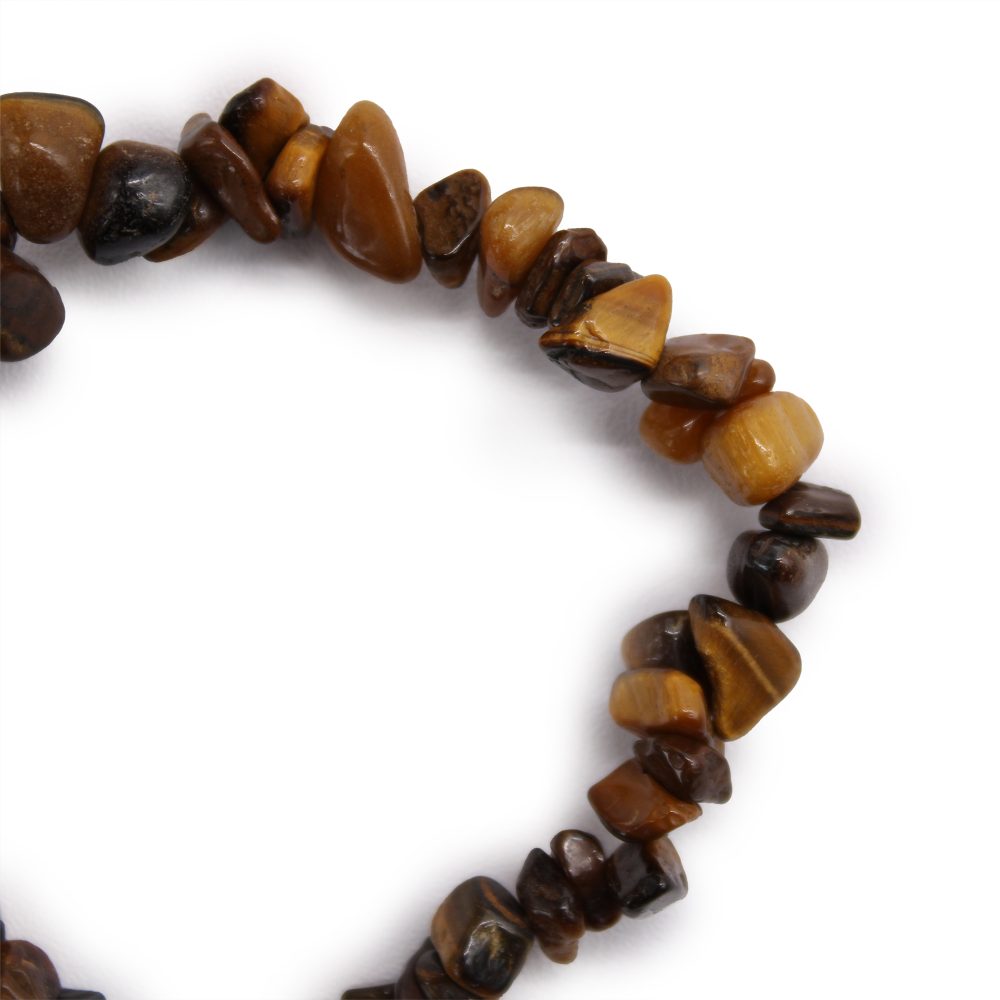 A bracelet made of small, polished tiger's eye stones sits on a plain white surface, forming a partial circle.