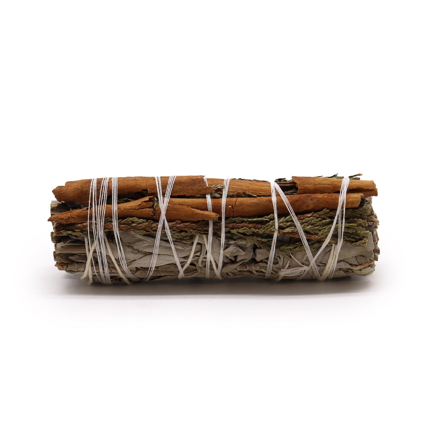 A smudge stick, bundled and tied with white twine, containing white sage, cedar, and cinnamon, rests on a white background.