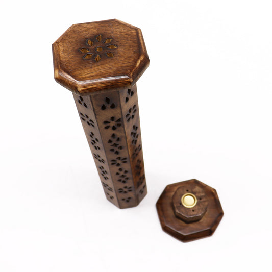 A carved wooden incense holder stands upright, decorated with floral patterns and an octagonal top. A matching lid lies adjacent, all set against a plain white background.