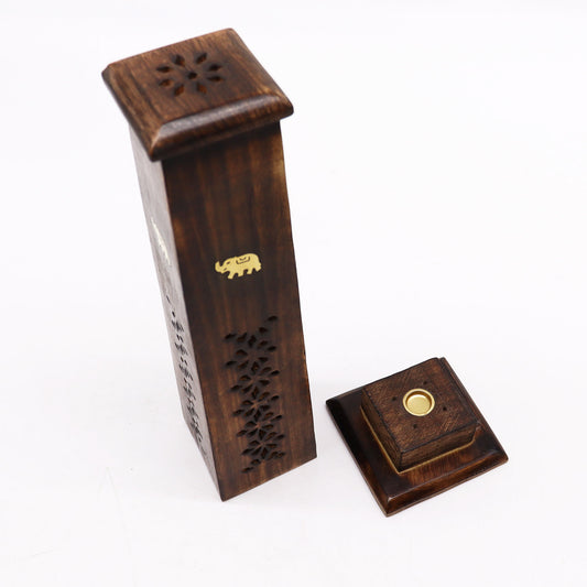 Wooden incense holder stands vertically with floral cutouts and a small elephant emblem. The removable square lid rests beside it. The setting is a plain white background.