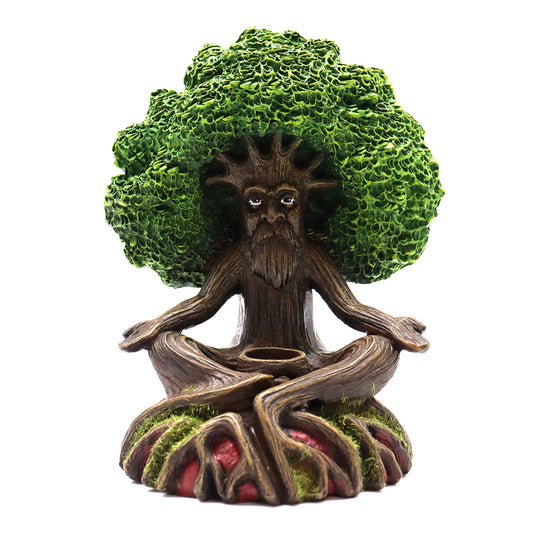 A tree-like figure with a human face meditates cross-legged. Its branches form a leafy canopy, and its roots spread over mossy ground. The figure is calm, set against a plain background.