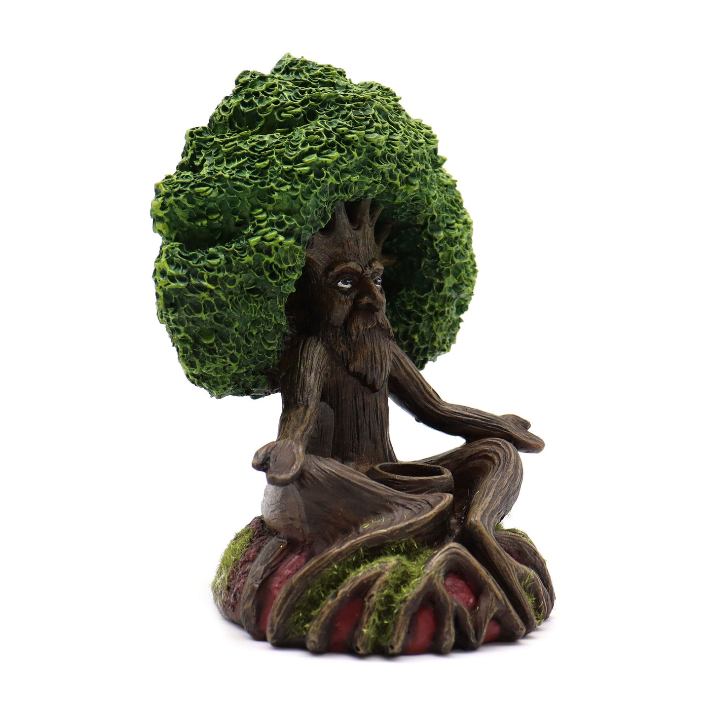 A tree-like figurine with a face and beard sits in a meditative pose, rooted on a moss-covered base, and has a lush, leafy canopy resembling hair.