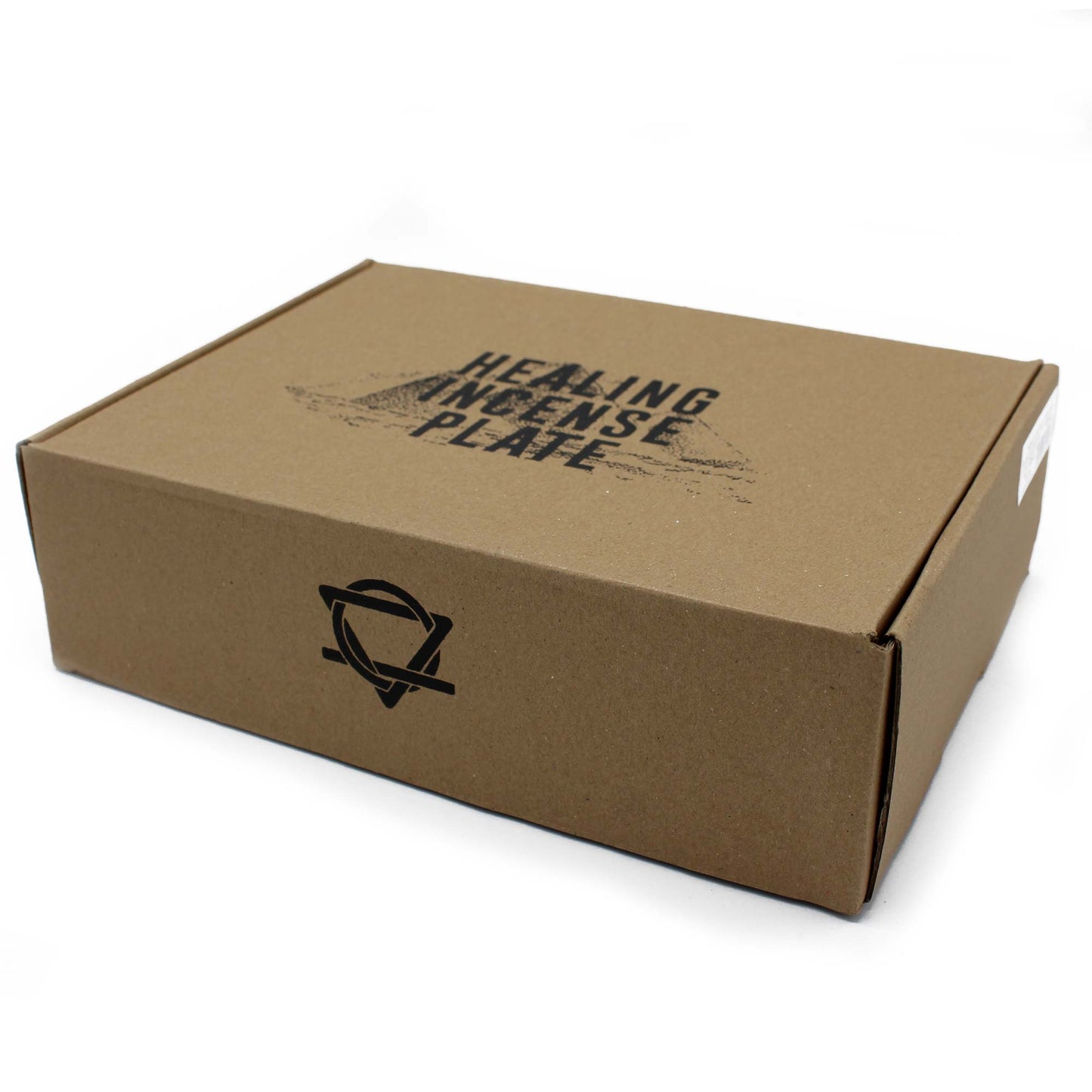 A brown cardboard box, labeled "HEALING INCENSE PLATE," rests on a white surface. It features a circular, interwoven logo on the front, with a small white sticker on the side.