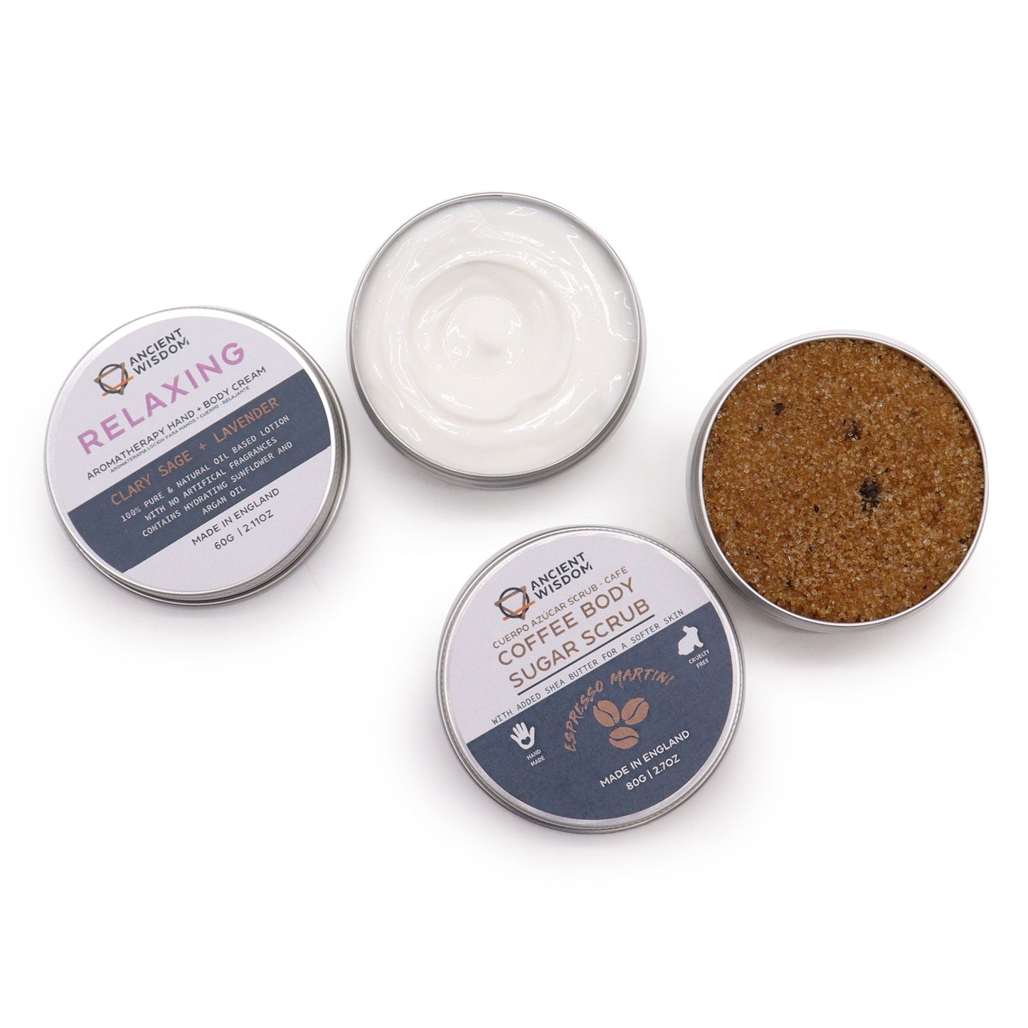 Three small tins sit on a white background. One contains a white cream, labeled “RELAXING,” with Clary Sage + Lavender. Another holds a brown sugar scrub, labeled “COFFEE BODY SUGAR SCRUB.” The third tin is out of focus.