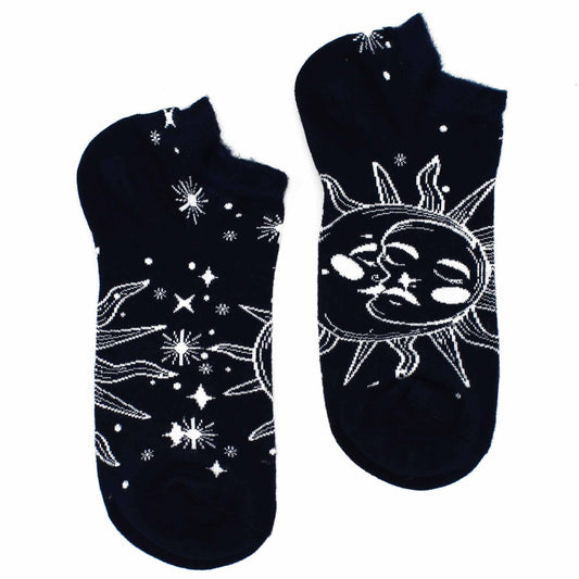 A pair of dark-blue ankle socks lies on a white background. Each sock features a celestial design of suns, moons, and stars in white.