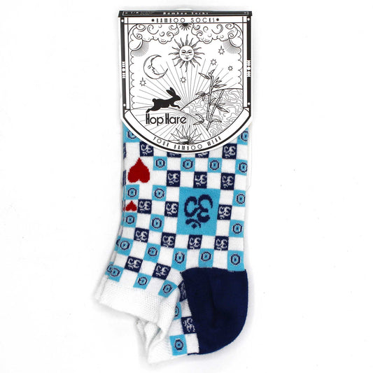A pair of ankle socks, featuring a blue and white checkered pattern and playing card symbols, stands against a white background. The socks have a navy blue heel and toe. The packaging displays the brand name "Hop Hare" and describes them as "Bamboo Socks."