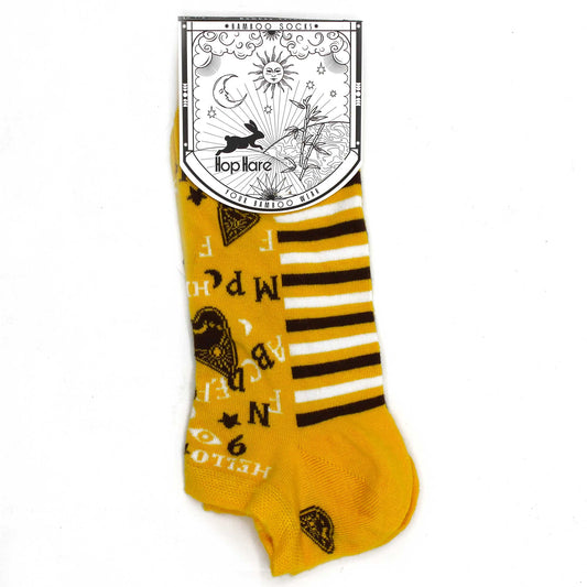 A yellow sock with brown and white stripes and patterns is displayed on a white background; attached is a tag that says "*BAMBOO SOCKS*", "Hop Hare", and "YOUR BAMBOO WEAR".