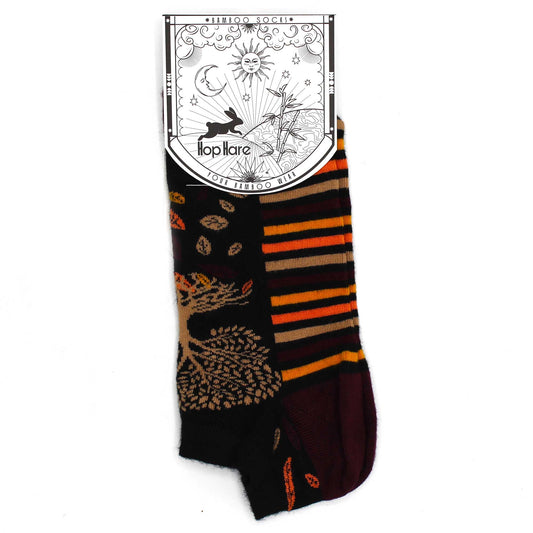 A bamboo sock, displaying an autumnal tree and stripe pattern, is presented against a white background with its attached tag. The tag reads: *BAMBOO SOCKS*, Hop Hare, YOUR BAMBOO WEAR.