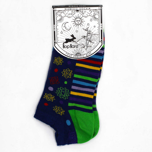 A pair of ankle socks, featuring a multicolored pattern, rests on a white background; attached is a tag with a rabbit design and the brand name "Hop Hare."