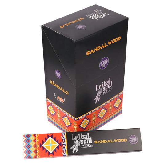 A black box labeled "Tribal Soul Incense Sandalwood" stands on a surface. It features colorful tribal patterns. A matching incense package lies horizontally below it. Additional text: "SÁNDALO" and "by HD."