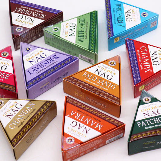 Triangular incense boxes labeled "Vijayshree Golden Nag" with various scents like Lavender, Palo Santo, and White Sage are arranged on a white surface.