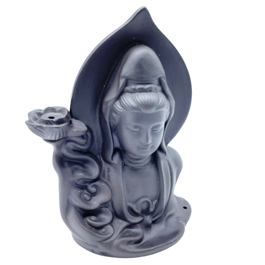 A dark statue depicts a serene figure with a hood, holding a lotus flower. Flowing drapery surrounds the figure's shoulders, set against a curved backdrop.